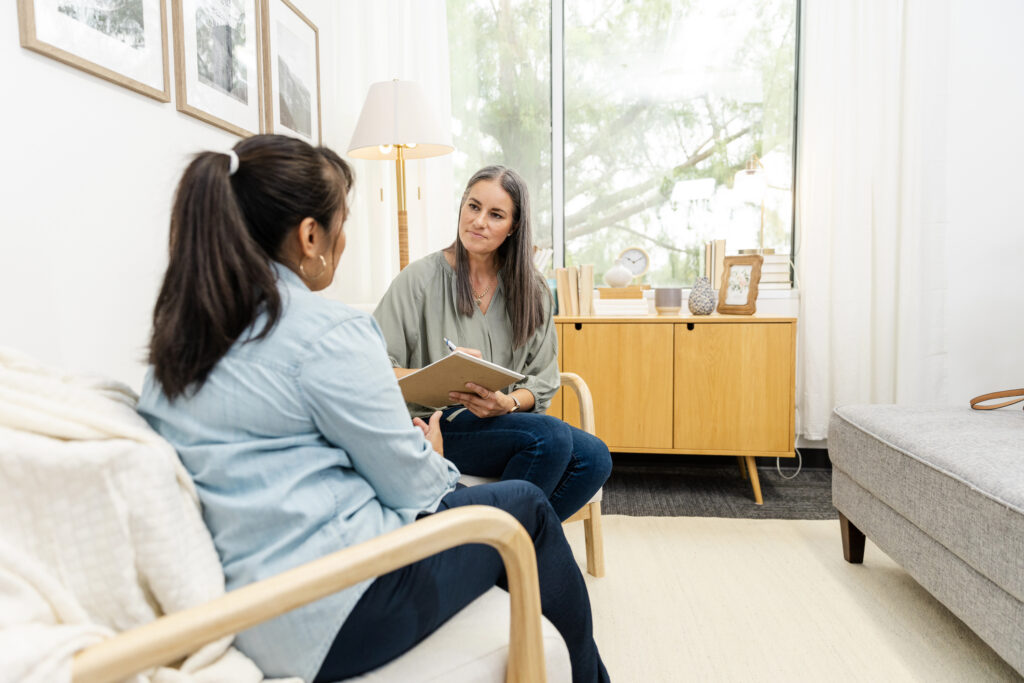 Therapist and client discussing topic in therapy room